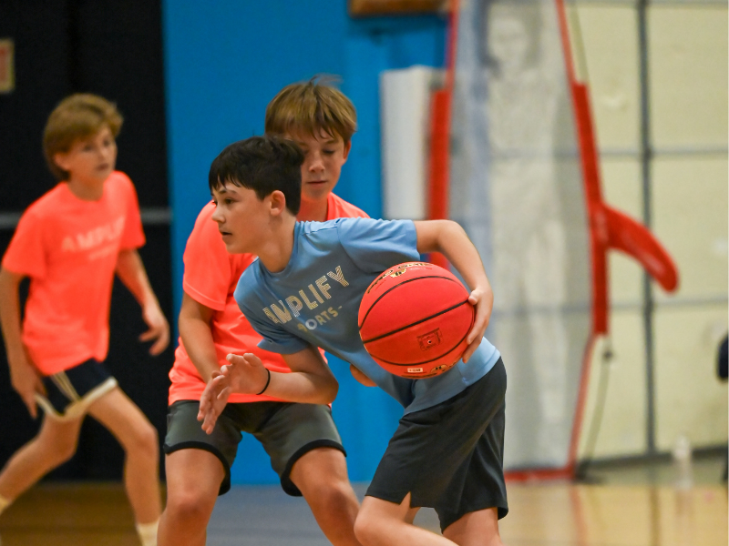 Youth basketball players competing in a supportive game environment at Amplify Sports