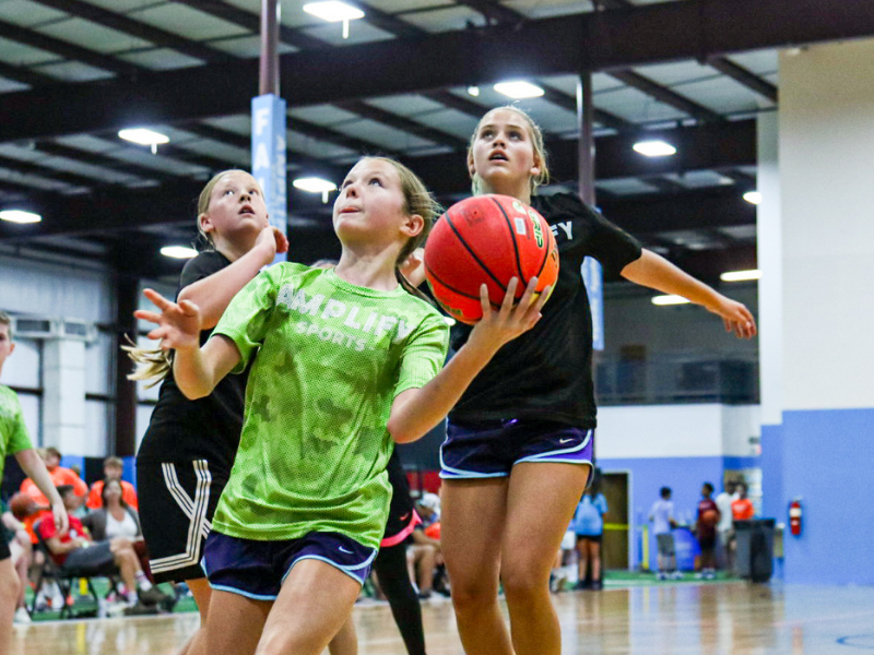 Youth basketball players participating in 3v3 games at Amplify Sports
